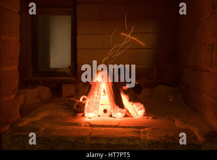 Aktivierte Holzkohle brennen im Inneren eines Ofens in Vorbereitung zum Grillen von Fleisch. Stockfoto