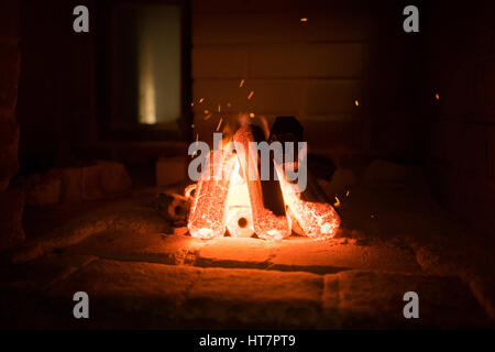 Aktivierte Holzkohle brennen im Inneren eines Ofens in Vorbereitung zum Grillen von Fleisch. Stockfoto