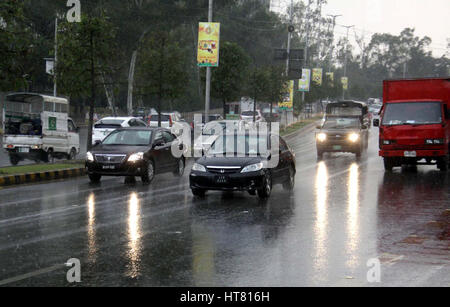 Pendler auf der Durchreise Straße während der schweren Platzregen der Wintersaison in Lahore auf Mittwoch, 8. März 2017. Stockfoto