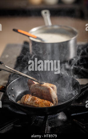 Stück Schweinefleisch braten in der Pfanne Stockfoto