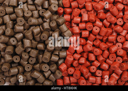 Braun mit roten vorgebohrte Heilbutt Pellets für Karpfen Angeln Hintergrund Stockfoto