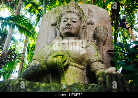Traditionelle Stein geschnitzte Statue im tropischen Garten Stockfoto