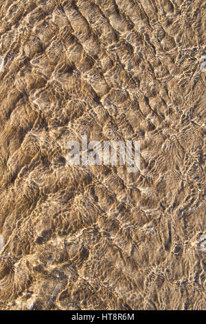 Flachwasser-Muster über Sand am Strand bei Ebbe. Muster von Meerwasser Rückzug am Strand gemacht. UK Stockfoto