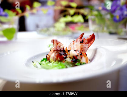 Festliches Mahl. Restaurant Hummer Gericht Blumenarrangement. Moderne Küche für Feierlichkeiten Stockfoto