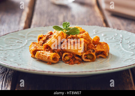 Gebratene Nudeln mit Ragu' Sauce auf Vintage Platte. Stockfoto