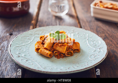 Gebratene Nudeln mit Ragu' Sauce auf Vintage Platte. Stockfoto