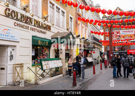 Touristen in Gerrard Street mit chinesischen Laternen für das chinesische Neujahrsfest eingerichtet. Chinatown, London, UK Stockfoto