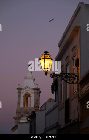 Bell Tower der Igreja de Santo Antonio und Straßenlaterne in der Abenddämmerung, Lagos, Portugal Stockfoto