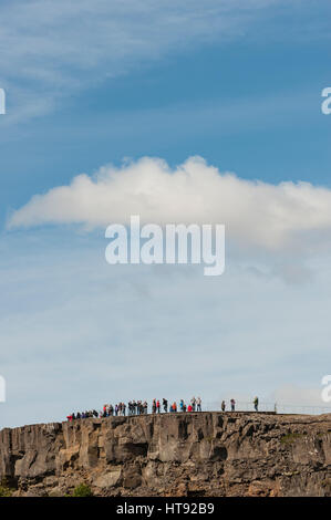 Touristen bewundern die Aussicht von oben auf einem Bergrücken in Thingvellir / Þingvellir National Park in Island. Stockfoto