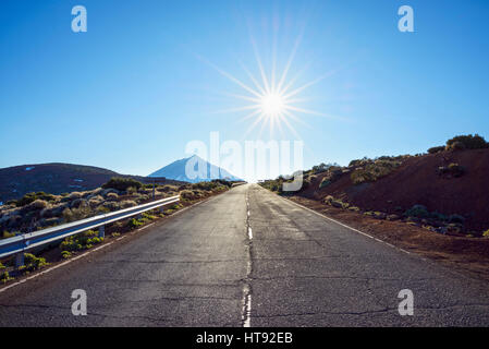 Straße mit Berg Pico del Teide und Sonne, Parque Nacional del Teide, Teneriffa, Kanarische Inseln, Spanien Stockfoto