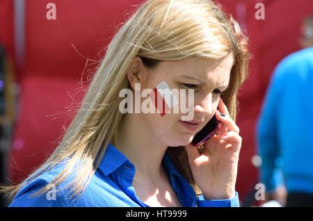 LONDON ENGLAND 9. Mai 2015: ziemlich polnische Mädchen mit Gesicht gemalt mit Flagge auf Handy Stockfoto