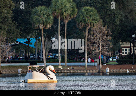 Touristen paddeln Swan Boote rund um Lake Eola Park in Orlando, Florida. Lake Eola Park ist gelegen im Herzen von Downtown Orlando und Heimat der Walt-Disney-Amphitheater. Stockfoto