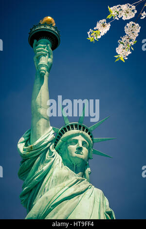 Freiheitsstatue mit blühenden Kirsche auf Vordergrund, New York Stockfoto