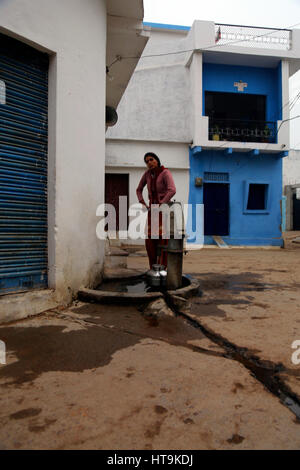 Unbekannte indische Frau in nehmen Sie Wasser aus dem öffentlichen Brunnen. Stockfoto