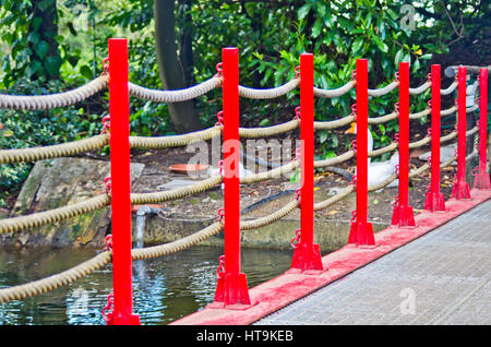 Fußgängerbrücke in Kunst aus Holz, rote Geländer gebaut und Hanf Seile in den Park von Pinocchio in Italien Stockfoto