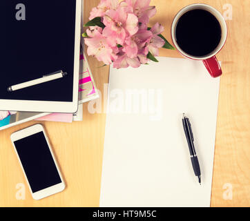 Bürotisch mit digitalen Tablet, Smartphone leeren Blatt Papier und eine Tasse Kaffee. Ansicht von oben mit Textfreiraum Stockfoto