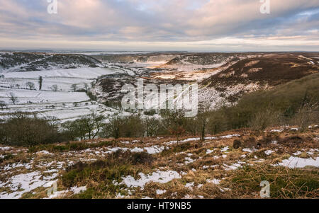 North York Moors im Winter mit Blick auf das Loch des Horcum nach Schneefall im Winter in der Nähe der Dörfer Levisham und Goathland, Yorkshire, Großbritannien. Stockfoto