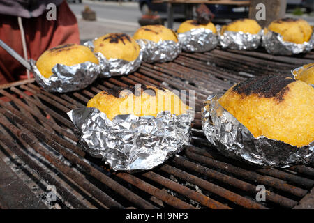 Traditionelle rumänische gegrillte Polenta mit Käse namens "Bulz" in Folie auf dem Grill in Transfagarasan Highway, Rumänien. Stockfoto