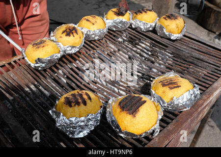 Traditionelle rumänische gegrillte Polenta mit Käse namens "Bulz" in Folie auf dem Grill in Transfagarasan Highway, Rumänien. Stockfoto