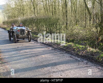 Ein Jahrgang, wie Austin Ulster Auto fahren entlang einer Landstraße - aufgenommen am John Harris Versuch, einem Oldtimer Sport-Event in Derbyshire organisiert durch VSCC Stockfoto