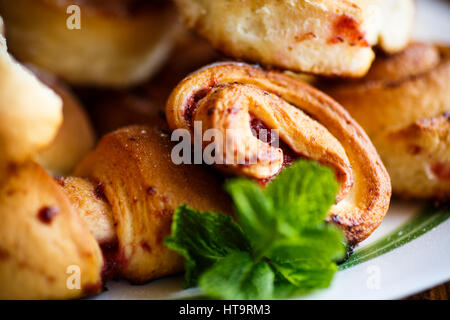 Süße Brötchen mit Marmelade auf einem Holztisch Stockfoto