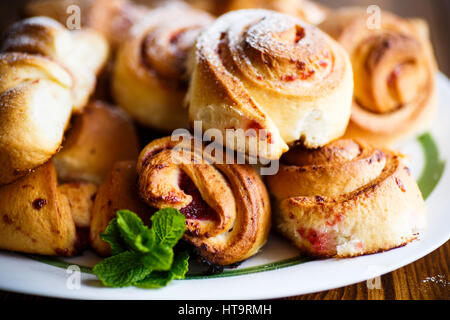 Süße Brötchen mit Marmelade auf einem Holztisch Stockfoto