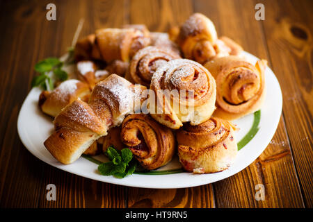 Süße Brötchen mit Marmelade auf einem Holztisch Stockfoto