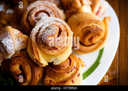 Süße Brötchen mit Marmelade auf einem Holztisch Stockfoto