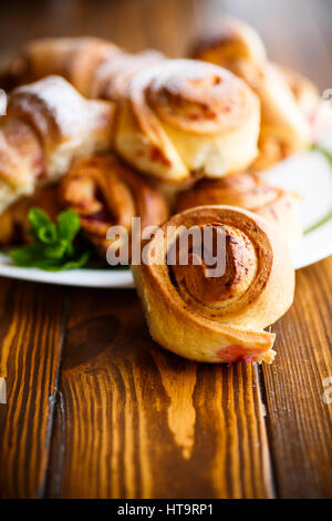 Süße Brötchen mit Marmelade auf einem Holztisch Stockfoto