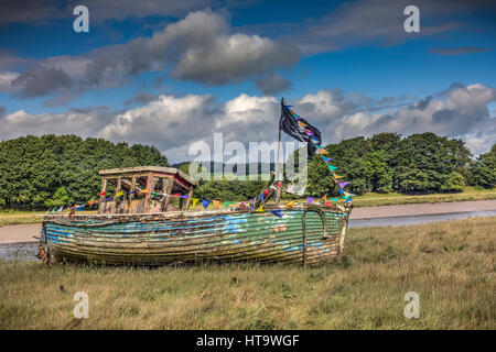 Ein altes Boot von Dee in Kirkcudbright dekoriert mit Girlanden und einem Schädel und gekreuzten Knochen Piraten-Flagge. Genommen in Dumfries and Galloway, Schottland, Großbritannien. Stockfoto