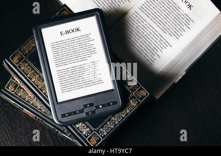 E-Book-Reader-Gerät auf Schreibtisch in der Bibliothek. Alternative für traditionelle Bücher Stockfoto