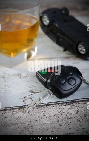 Autoschlüssel, Glas Whiskey im Hintergrund. Fahren unter Alkoholeinfluss Stockfoto