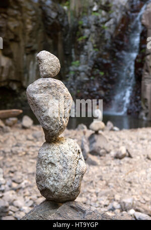 Steinen im Gleichgewicht vor einem Wasserfall Stockfoto