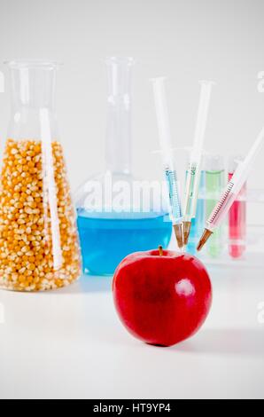 Drei Spritzen in roten Apfel. Gentechnisch veränderte Lebensmittel in Lab Konzept. Stockfoto
