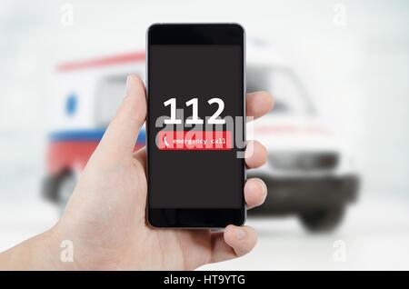 Mann ruft Notfall. Ambulanz im Hintergrund. Notruf 112 Hilfe Mann Konzept Stockfoto