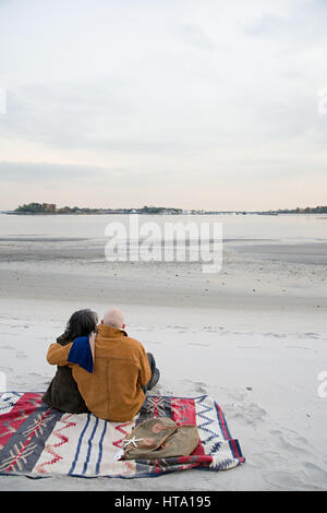 Älteres Paar am Strand sitzen Stockfoto