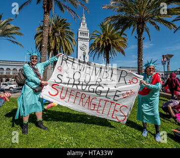 San Francisco, USA. 8. März 2017.  Zwei Frauen gekleidet wie die Statue of Liberty in Ketten drapiert und Rallye-roten Schärpen mit ihren Zeichen darstellen "Remember unser Kampf Suffragetten" vor dem San Francisco Ferry Gebäude am Justin Herman Plaza während des internationalen Frauentages. Bildnachweis: Shelly Rivoli/Alamy Live-Nachrichten Stockfoto