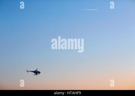 Küstenwache Hubschrauber fliegen gegen blauen Himmel Stockfoto