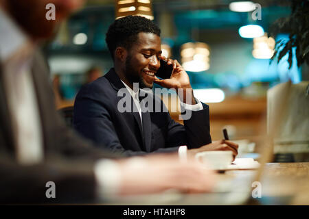 Geschäftige Unternehmer sprechen am Telefon und Arbeitsplan Stockfoto