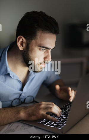 Freiberufler, die Suche nach Informationen im Netz während der Arbeit in der Nacht Stockfoto