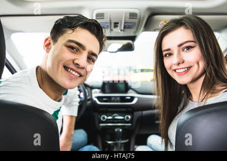 Attraktives Paar wählt ein neues Auto im Showroom, Auto-Kauf und Erfolg-Konzept, im Auto zu sitzen Stockfoto