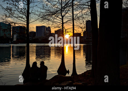 Skyline-Blick über Lake Eola und Palmen Bäume bei Sonnenuntergang in Orlando, Florida. Lake Eola Park ist gelegen im Herzen von Downtown Orlando und Heimat der Walt-Disney-Amphitheater. Stockfoto