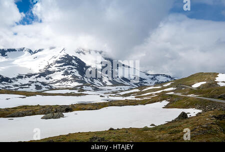 Blick auf die Berge und berühmte County Road 55 - spektakuläre norwegische serpentine Bergstraße liegt Schnee im Sommer. Sognefjellet, Norwegen. Stockfoto