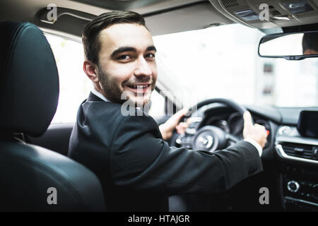 Auto Autoverkauf, Business, Lifestyle und People-Konzept - der Mann sitzt im Cabrio Auto am Auto Show oder Salon hautnah Stockfoto