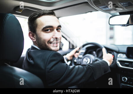 Auto Autoverkauf, Business, Lifestyle und People-Konzept - der Mann sitzt im Cabrio Auto am Auto Show oder Salon hautnah Stockfoto