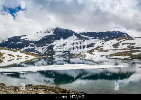 Berglandschaft mit schneebedeckten Felsen und Schmelzwasser See mit schöne Reflexion. Straße 55, National Tourist Route, Norwegen. Stockfoto