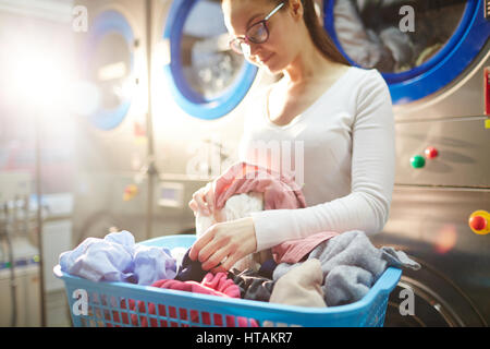Junge Frau mit Kleidung in der Wäsche Stockfoto