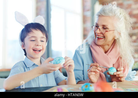 Kleine Junge und ältere Weibchen machen Ostern Eiern für Urlaub Stockfoto