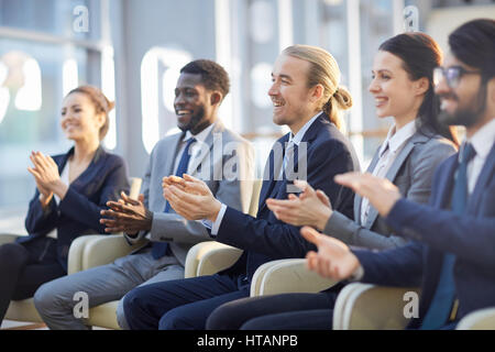 Reihe von Geschäftsleuten Händeklatschen nach Bericht des Lautsprechers Stockfoto