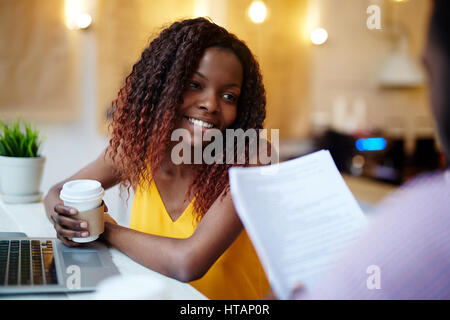 Hübsche junge Frau im Gespräch mit ihrem Kollegen im café Stockfoto
